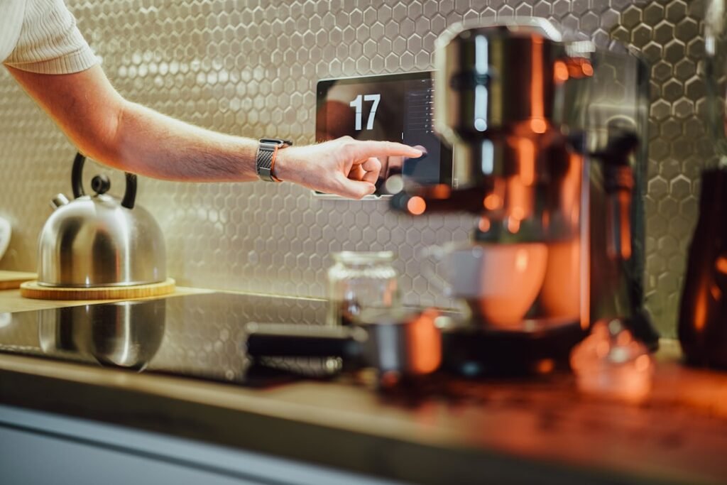Person using a wall-mounted home control screen in a kitchen